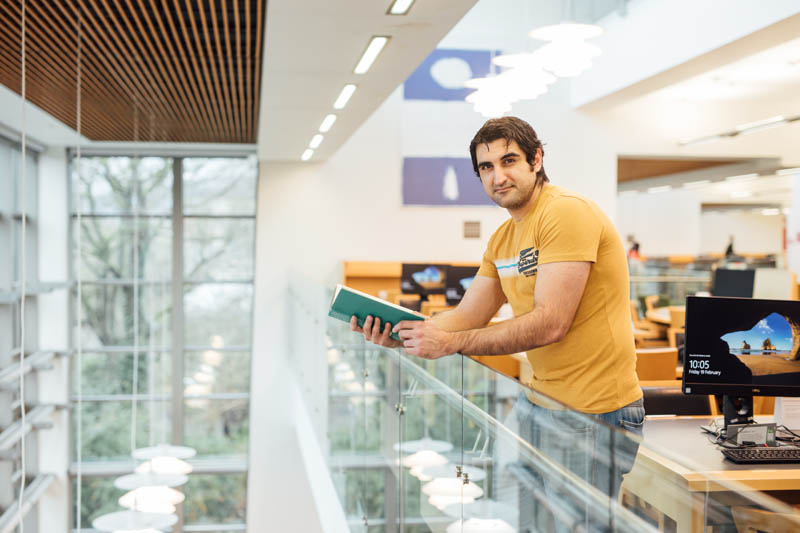 Image of student in McClay Library overlooking balcony