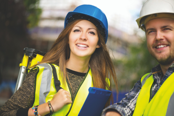 female engineer talking to a colleague both wearing hard hats