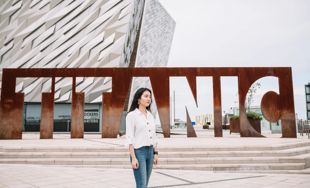 A woman standing in front of the Titanic Exhibition