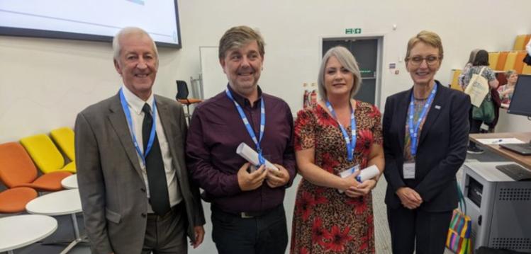 Two men and two women at awards ceremony