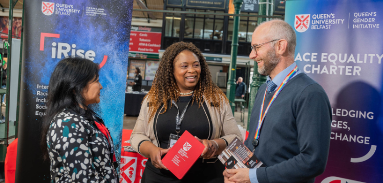 Adone, JustHer Network rep and Maurice Macartney chatting at the Black History Month expo, St George's Market