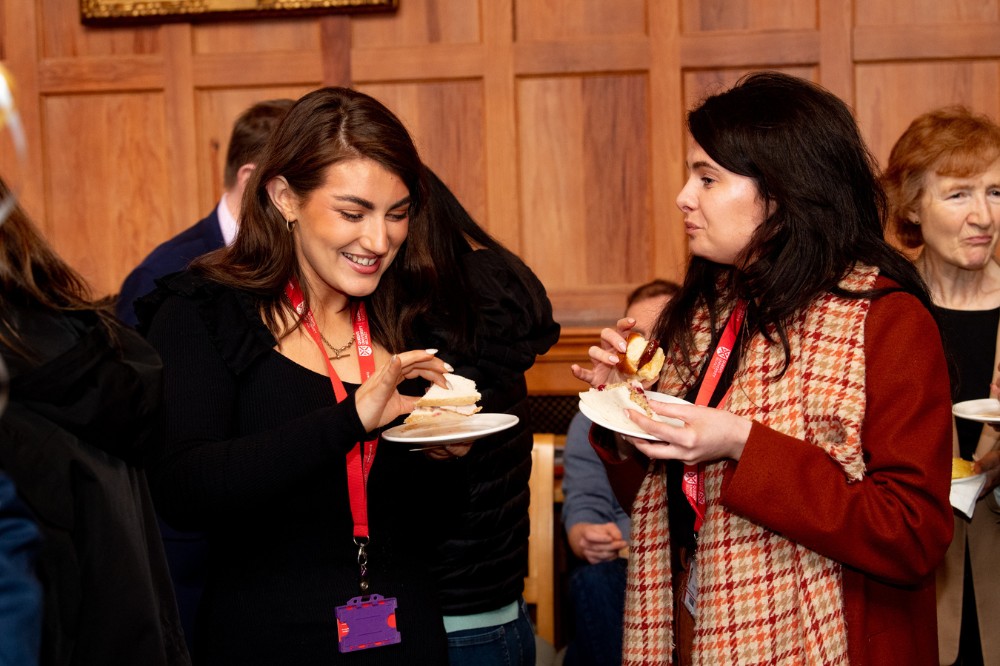 two smiling women chatting over a buffet lunch