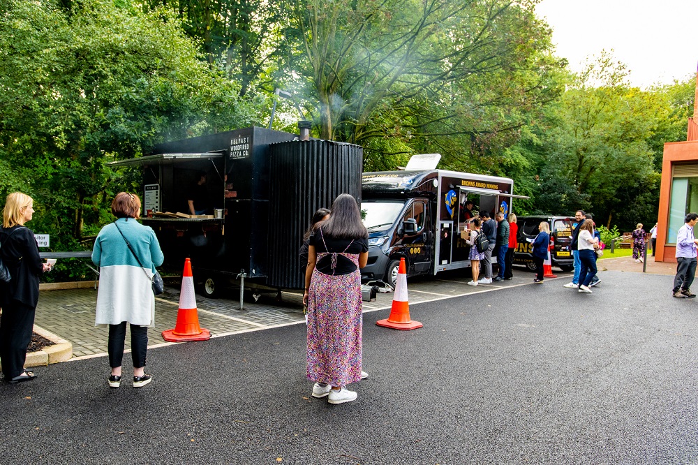 people ordering food and waiting at a food truck outside Queen's Business School