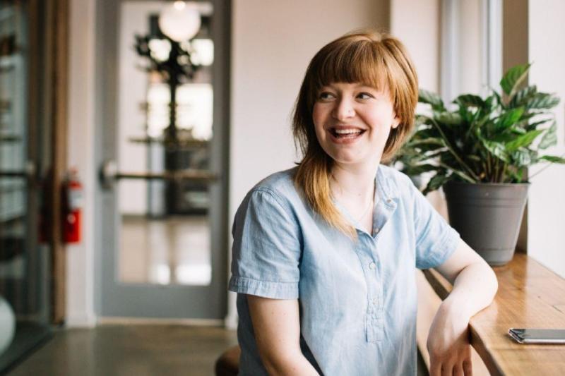 young woman smiling in an open hallway