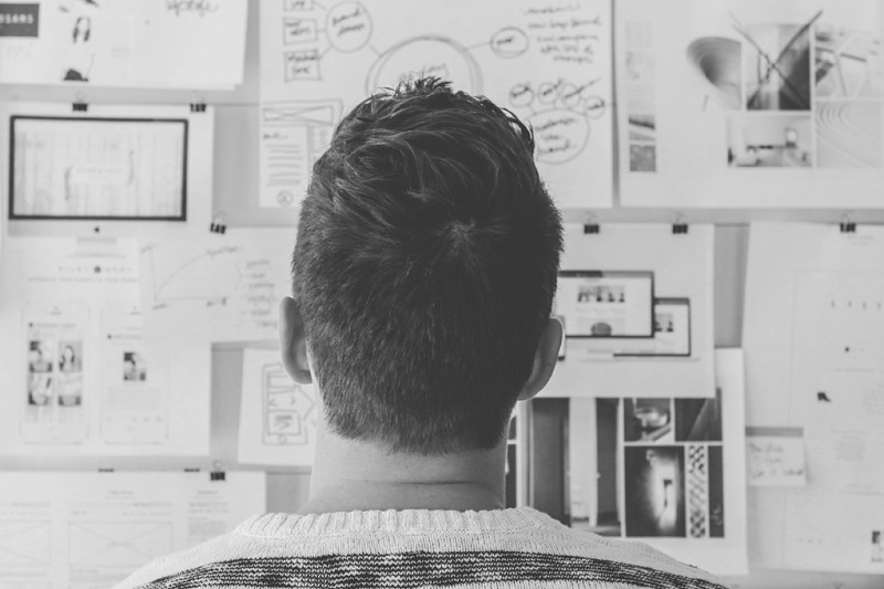 man looking at research data on a board