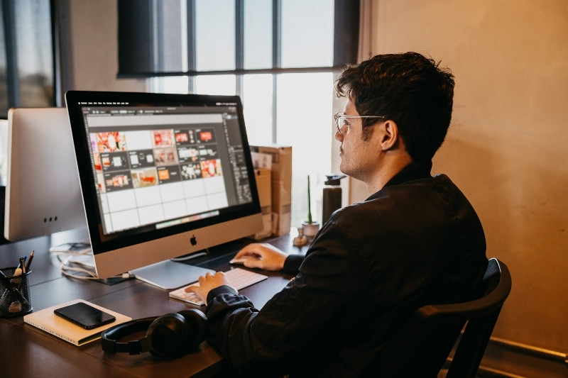 seated man working on a PC in a low-lit, quiet office environment