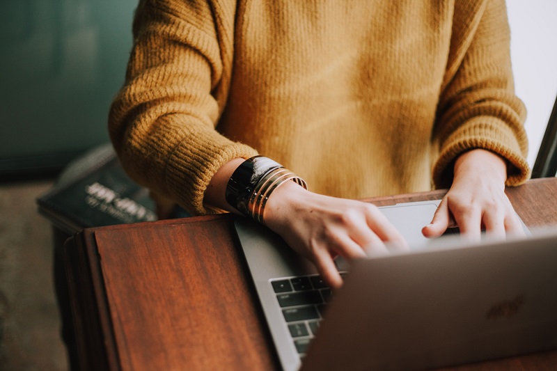 young woman sitting at a table and working on a laptop